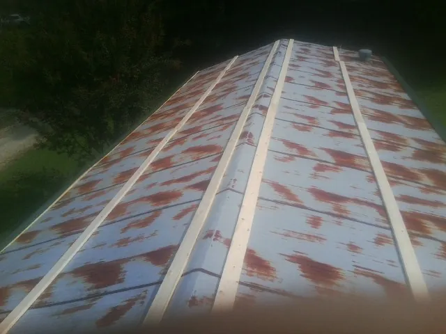 Rusted metal roof panels with new wood purlins before replacement — Storm Damage Roof Repair in Atchison by Roofing Brothers
